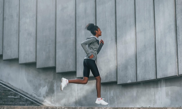 Conception du sport Une jeune femme afro-américaine en vêtements sportifs s'entraîne à l'extérieur pendant la journée