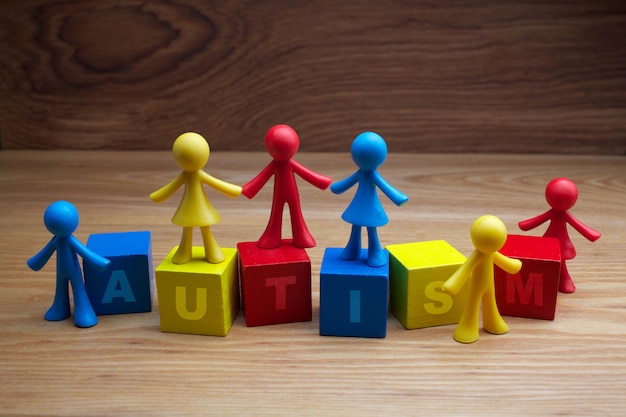 Photo conception de fond enfants poupée avec mot autisme sur cubes