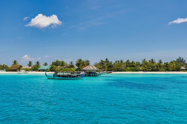 Conception inspirante de la plage des Maldives. Bateau traditionnel des Maldives Dhoni et baie parfaite du lagon de la mer bleue