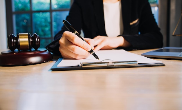 Conception de la justice et du droitJudge masculin dans une salle d'audience avec le marteau travaillant avec l'ordinateur et le clavier d'amarrage des lunettes sur la table à la lumière du matin