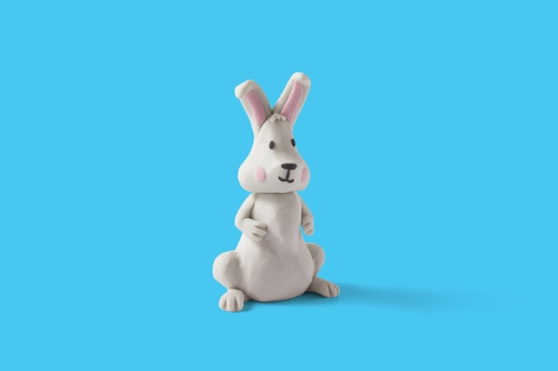 Conception de lapin blanc de Pâques faite à la main avec de la pâte à modeler sur fond bleu