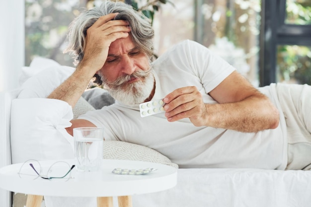 Conception de la maladie et du virus Senior homme moderne et élégant aux cheveux gris et à la barbe à l'intérieur