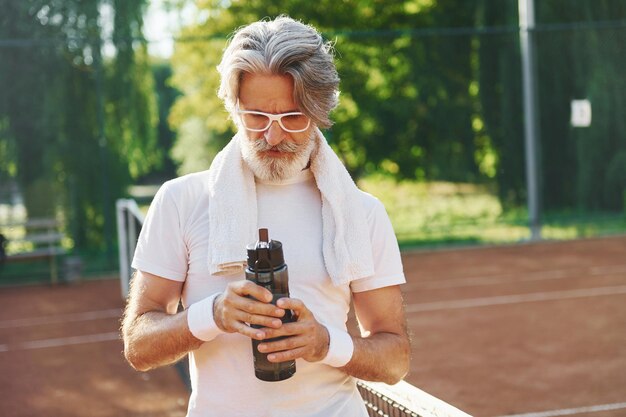 Conception de la mode en lunettes de soleil Senior homme élégant moderne à l'extérieur sur le terrain de sport pendant la journée