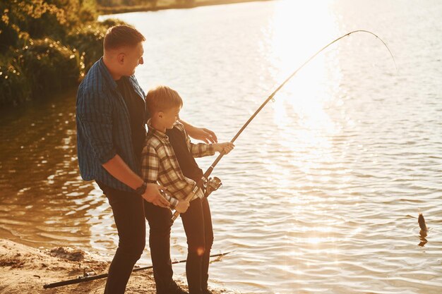 Conception de passe-temps Père et fils sur la pêche ensemble à l'extérieur en été