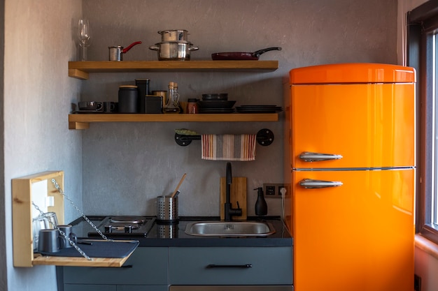 Conception d'une petite cuisine de style loft avec un réfrigérateur orange