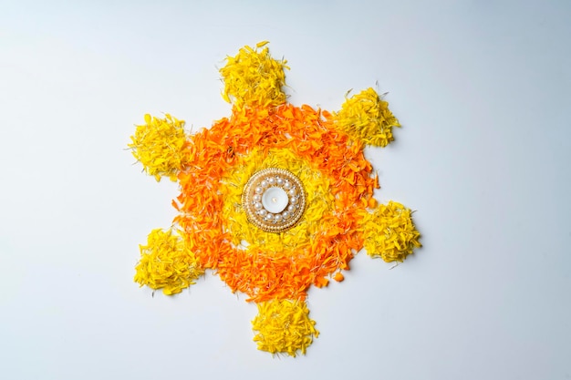 Photo conception de rangoli de fleur de souci avec des lampes à huile pour le festival de diwali.