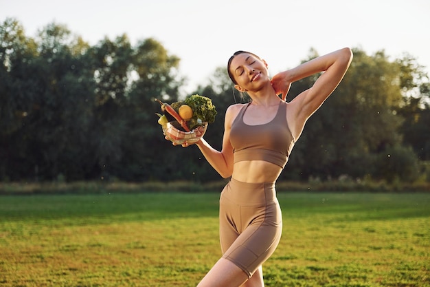 Conception de régime et de perte de poids Jeune femme en vêtements de yoga est à l'extérieur sur le terrain