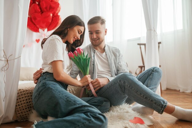 La conception de la Saint-Valentin embrasse un jeune couple ensemble à la maison