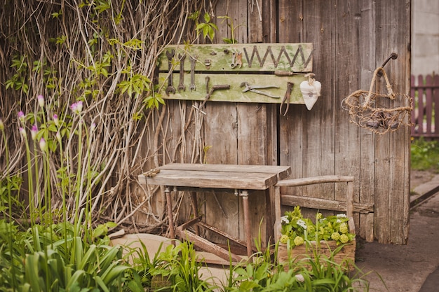 Conception de la zone de photo dans un style rustique, vieilles portes et planches en bois avec outils et fleurs printanières.