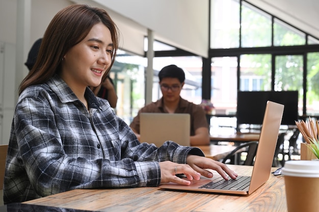 Conceptrice de femme asiatique travaillant avec un ordinateur portable dans un bureau de création.