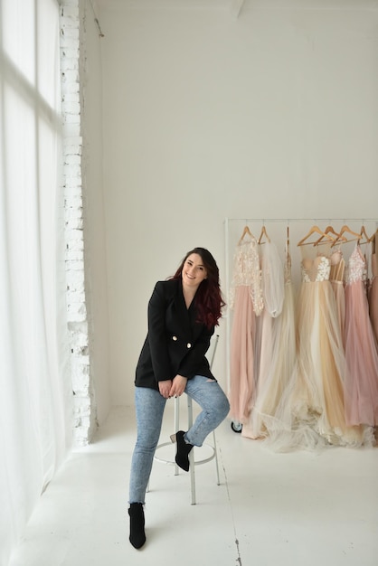 Conceptrice de femme heureuse à côté de ses robes