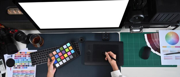 Conceptrice travaillant sur un ordinateur moderne et une tablette graphique dans un bureau de création