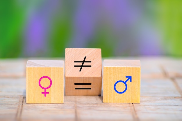 Photo concepts d'égalité des sexes. cube en bois avec symbole changement inégal en signe égal