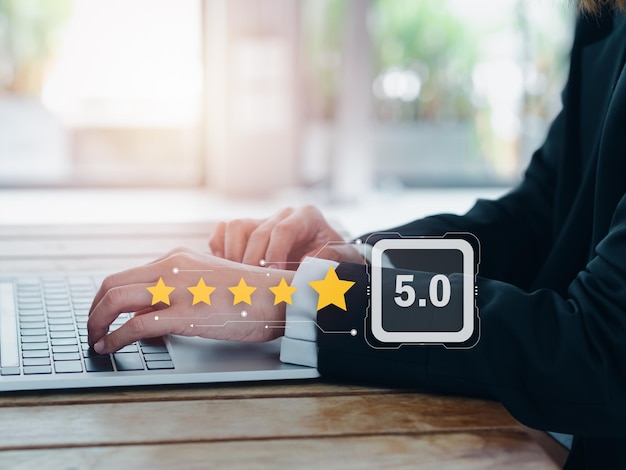 Concepts d'enquête de satisfaction des avis clients Cinq étoiles et 5 points apparaissent lorsque l'homme d'affaires utilise un ordinateur portable donne des commentaires sur l'expérience de service et l'évaluation du site Web en ligne