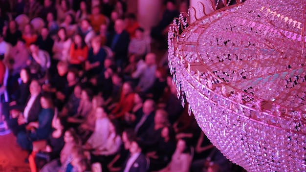 Un concert dans la salle de concert avec un grand lustre en cristal Personnes assises sur les chaises