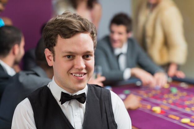 Concessionnaire debout à la table de roulette