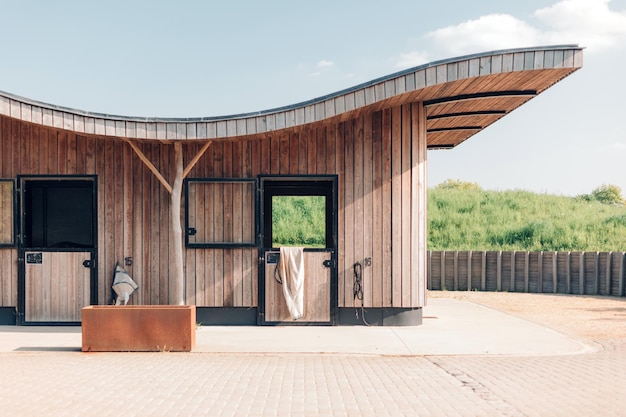 Concevoir des écuries dans un centre d'éducation équestre ferme équestre moderne avec des structures en bois et en acier à la lumière du jour