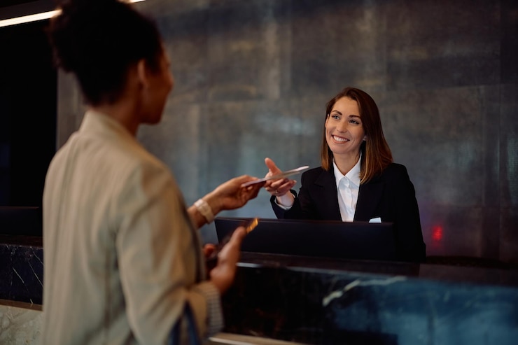 Photo un concierge heureux qui parle à un invité qui s'enregistre à l'hôtel.