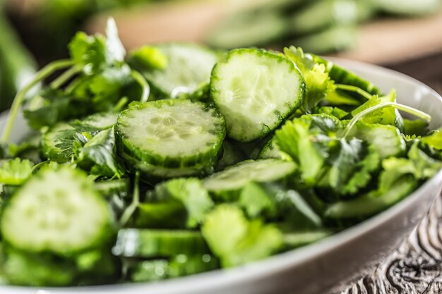 Concombre tranché sur une assiette avec du persil aux herbes sur bois de chêne rustique.