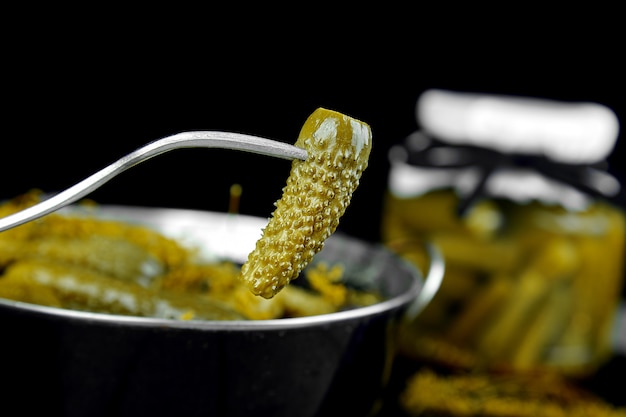 Des concombres en conserve dans une poêle en métal.