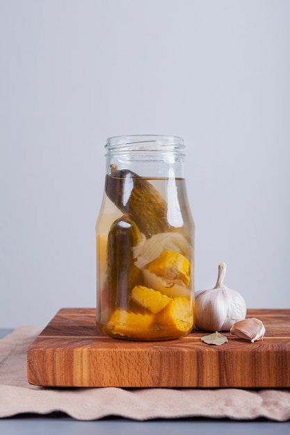 Concombres fermentés et courges sur une table dans un bocal en verre