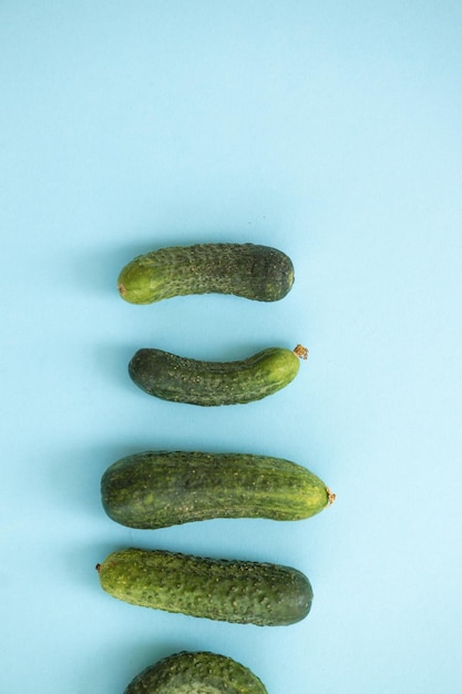 Concombres frais entiers mûrs sur fond bleu