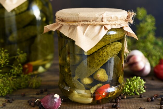 Concombres marinés à l'aneth et à l'ail dans un bocal en verre.