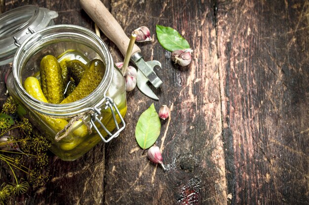 Concombres marinés aux herbes et épices. Sur un fond en bois.