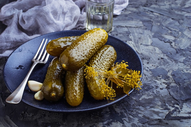 Concombres marinés dans une assiette noire. Mise au point sélective