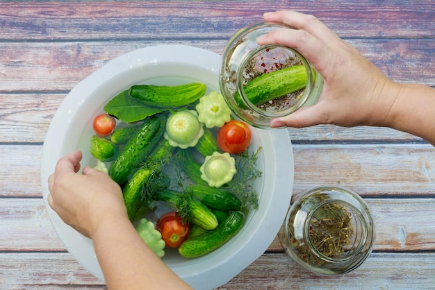 Concombres marinés et tomates dans des bocaux en verre