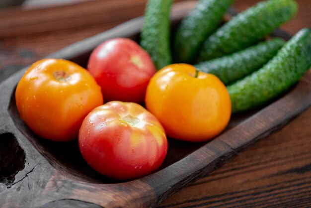 Concombres et tomates frais sur un fond en bois.