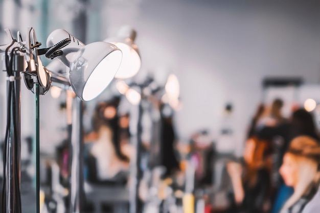 Concours stylistes coiffeurs à l'exposition de coiffures et de maquillage L'arrière-plan est flou l'accent est mis sur la lampe Concept de coiffure