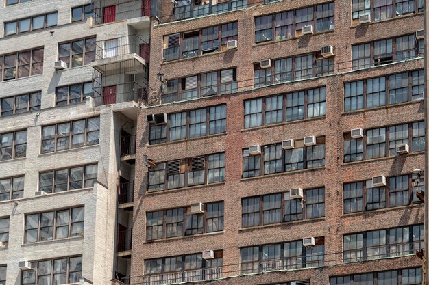 Photo des condos à manhattan, à new york. des vieilles fenêtres et des appareils de climatisation.