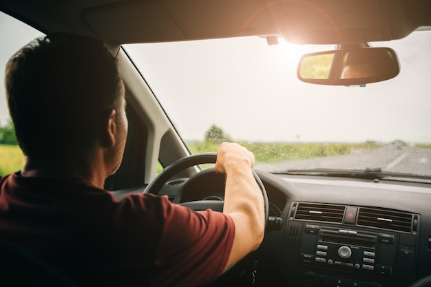 Conducteur au volant. Homme conduisant la voiture sur la route.