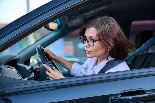 Conducteur de belle femme d'âge moyen conduisant une voiture