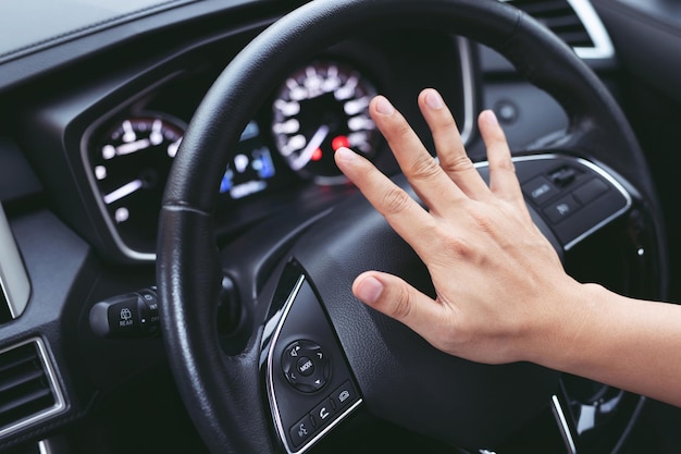 Un conducteur en colère klaxonne et crie en s'asseyant devant un embouteillage.