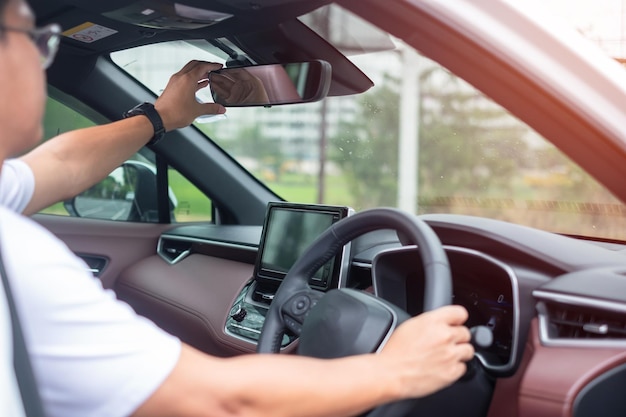 Conducteur de l'homme ajustant le rétroviseur d'une voiture Voyage voyage et sécurité Concepts de transport