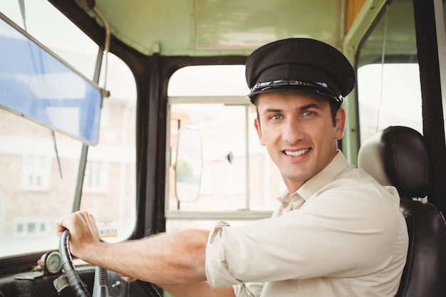 Conducteur souriant conduisant le bus scolaire