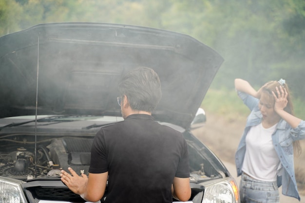 Un Conducteur Vérifie L'état D'une Voiture Après Un Accident Avec Un Moteur Qui Fume