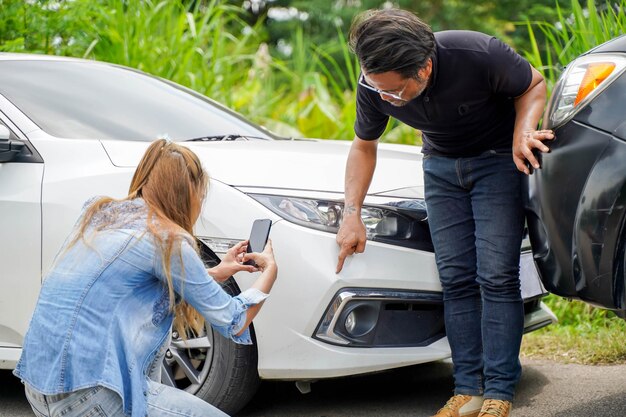 Une conductrice en gros plan utilise des téléphones portables pour prendre des photos comme preuve de réclamations d'assurance