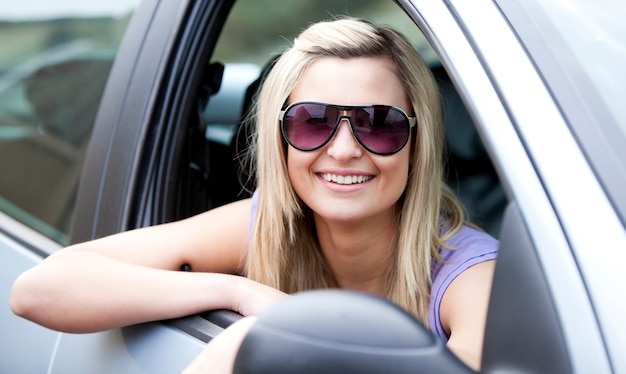 Conductrice Jolly porter des lunettes de soleil assis dans sa voiture