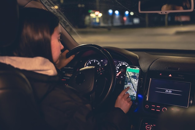 Conduire une voiture la nuit une femme conduisant sa voiture moderne la nuit dans la ville