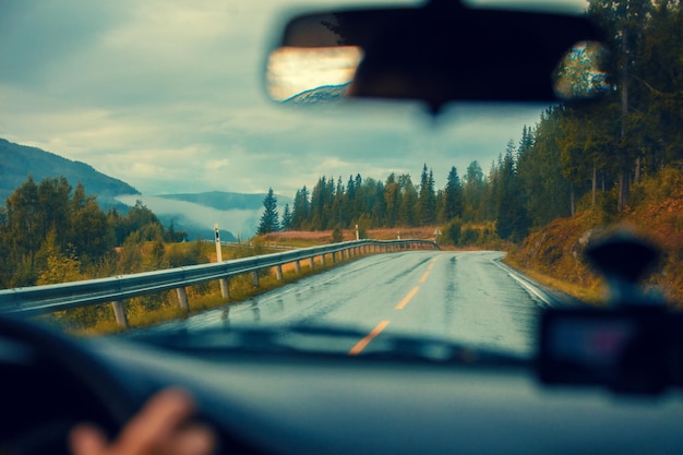 Conduire une voiture sur la route de montagne Route parmi les montagnes avec le spectaculaire ciel nuageux orageux Paysage Belle nature Norvège