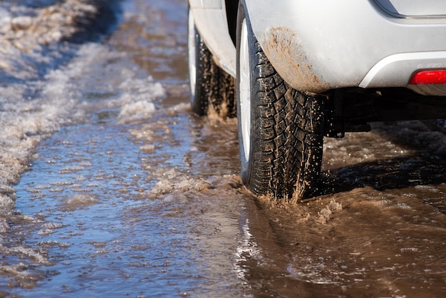 Conduite en campagne pendant la saison de fonte des neiges Printemps sur des chemins de terre remplis de flaques d'eau