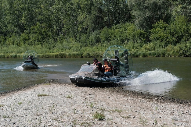 Conduite à grande vitesse dans un hydroglisseur sur la rivière un jour d'été avec des éclaboussures et des vagues