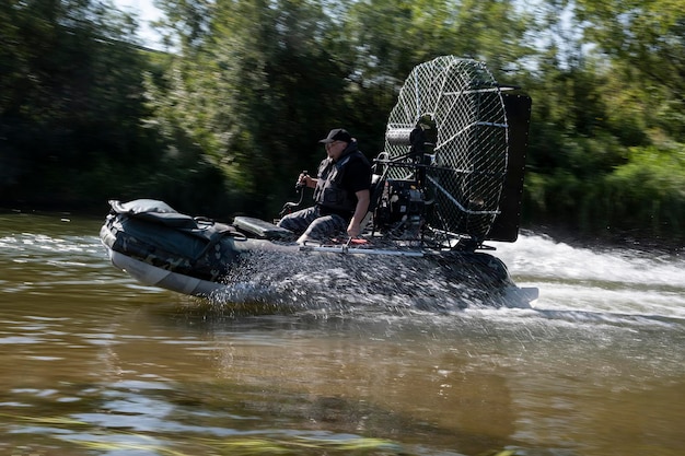 Conduite à grande vitesse dans un hydroglisseur sur la rivière un jour d'été avec des éclaboussures et des vagues