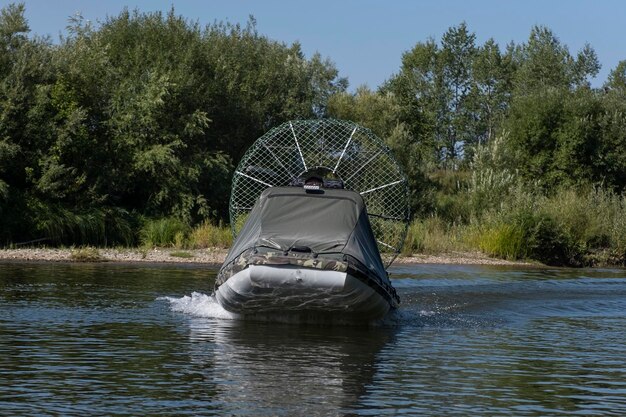 Conduite à grande vitesse dans un hydroglisseur sur la rivière un jour d'été avec des éclaboussures et des vagues