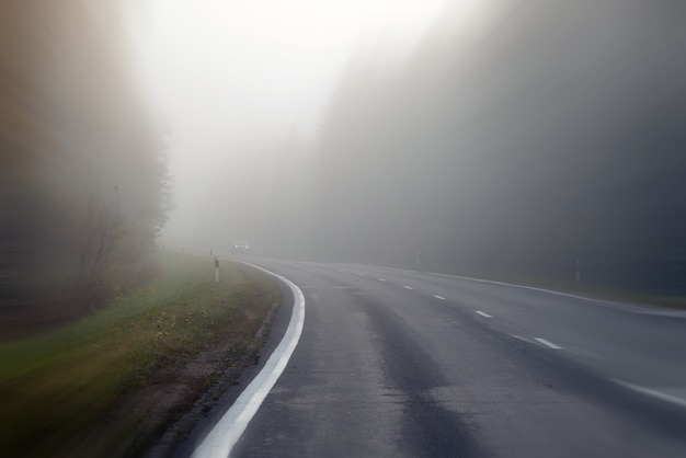 Conduite sur route de campagne dans le brouillard. Illustration des dangers de la conduite par mauvais temps : brumeux, difficile à voir devant