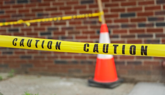 Un cône d'avertissement est affiché sur un mur de briques.