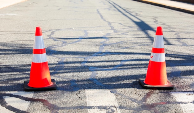 Photo cône de construction de rue orange sur la route avec un fond flou symbolisant la prudence et le travail en cours